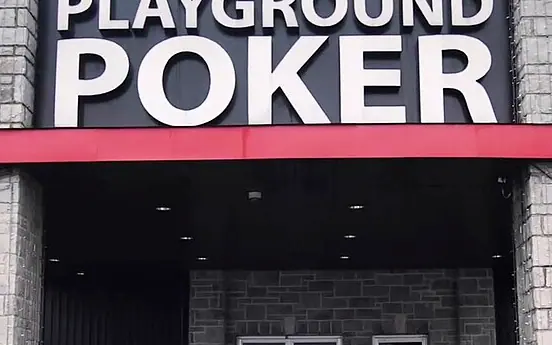 Stone-pillared entrance of the Playground Poker Club in Kahnawake under its PLAYGROUND POKER sign, photographed in 2018