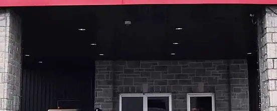 Entrée à piliers de pierre du Playground Poker Club à Kahnawà:ke, sous l'enseigne PLAYGROUND POKER, photographiée en 2018